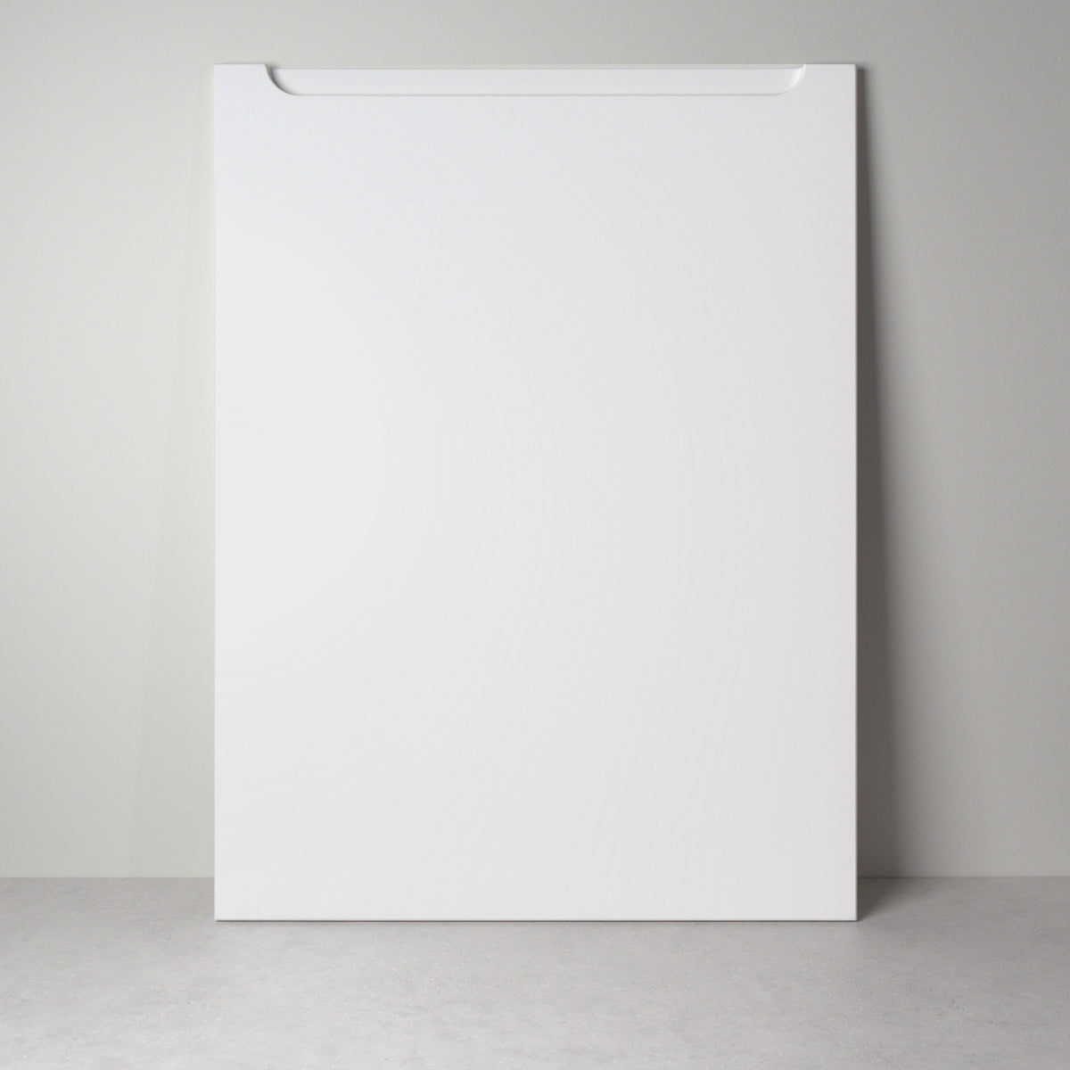 Grip front for IKEA furniture in white lacquer, leaning against a wall, milled handle pocket at the top edge