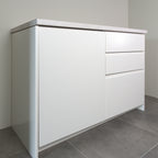 Milled Handle fronts in white lacquer on a kitchen cabinet, angled view from the left