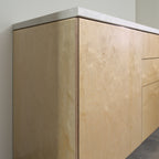 Corner of a cabinet with birch plywood fronts and side panel, angled view from the left