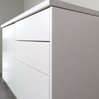Smooth fronts in white lacquer on a kitchen cabinet, angled view from the right