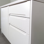 Drawers with Grip fronts in white lacquer, handle pockets with rounded ends, angled view from the right