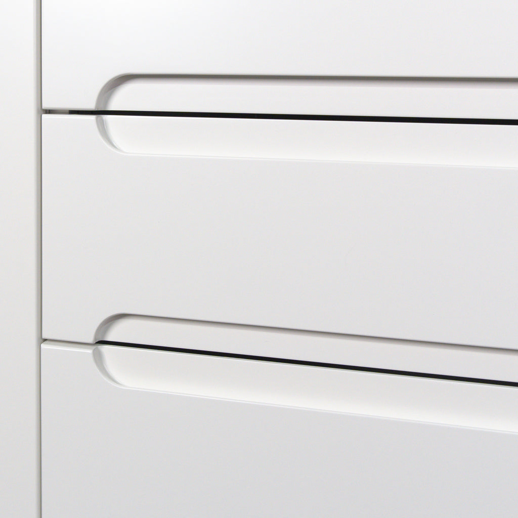 Handle pocket with a rounded end at the top edge of a drawer, Grip front in white lacquer close up