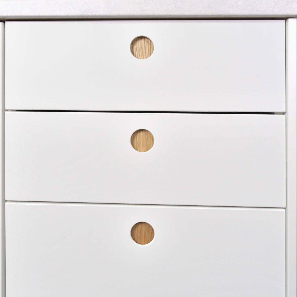Drawers with white Round Oak fronts and round oak-lined handles, detail