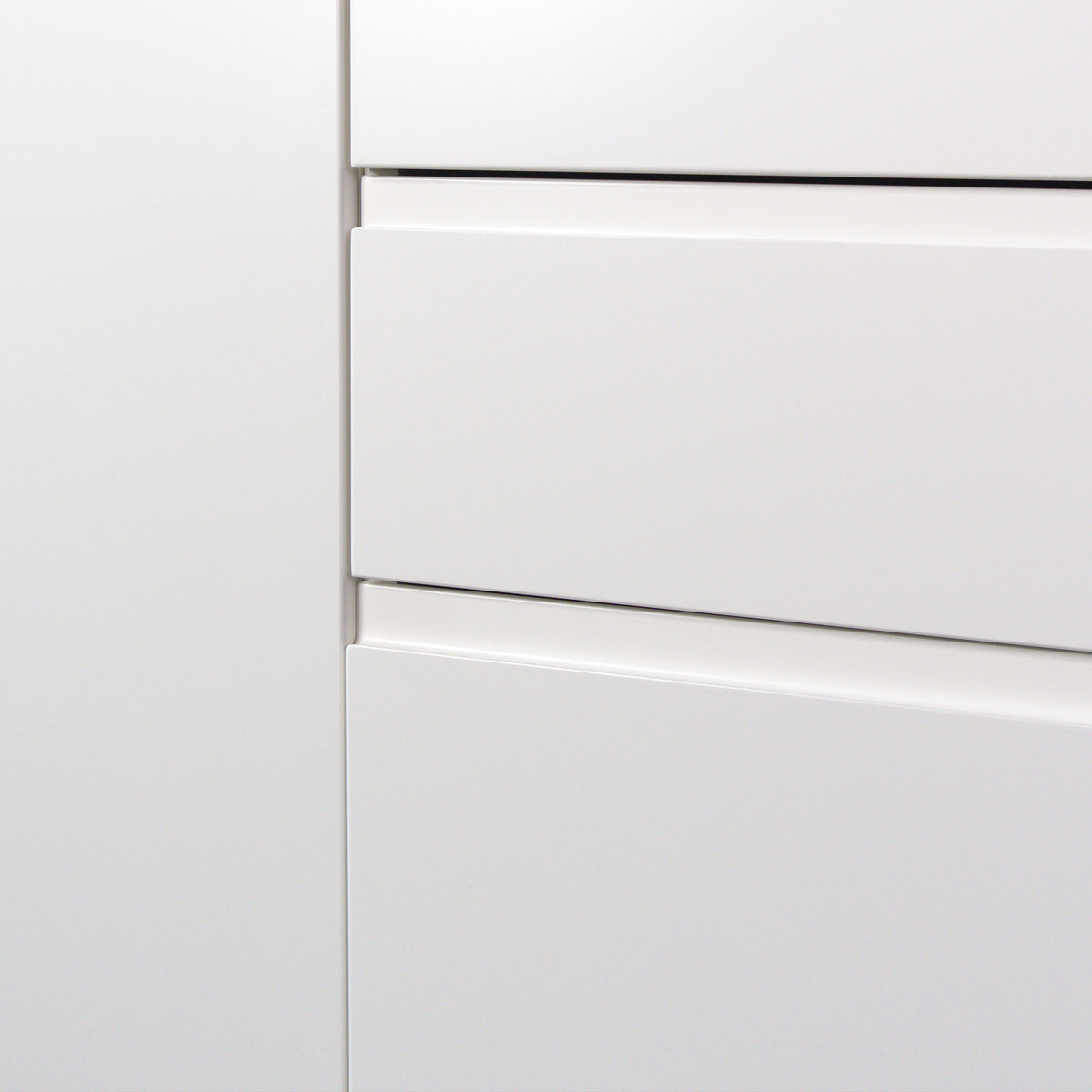 Handle undercut across the full drawer width, Milled Handle fronts in white lacquer close up
