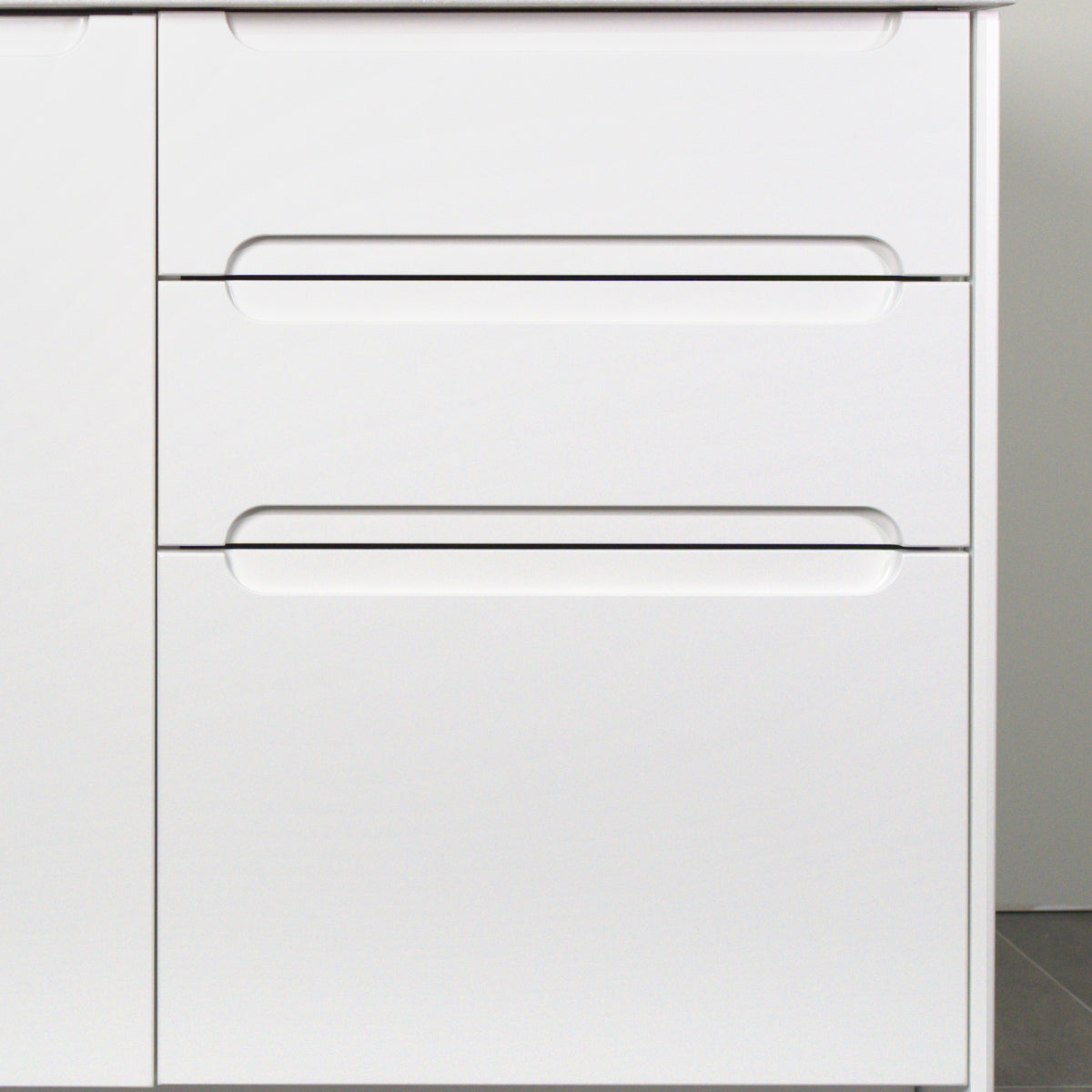 Three drawers with Grip fronts in white lacquer, handle pockets end before the sides of the front