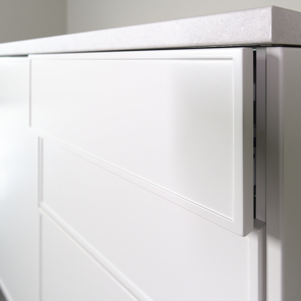 Pulled out drawer with a Linea front, showing the 19 mm front edge and the frame, white lacquer