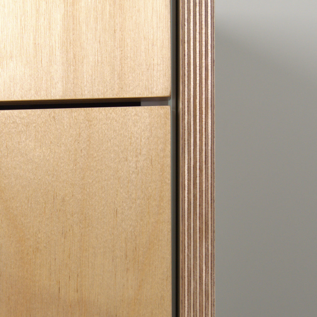 Edge of birch plywood with visible layers, side panel next to drawer fronts